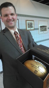 Principal Dan Krofcheck holds an NFL Super Bowl "golden football" given to the school by the NFL to commemorate the 50th Super Bowl game. Russ Grimm, a 1977 Southmoreland graduate, played in three Super Bowls and coached in a fourth.